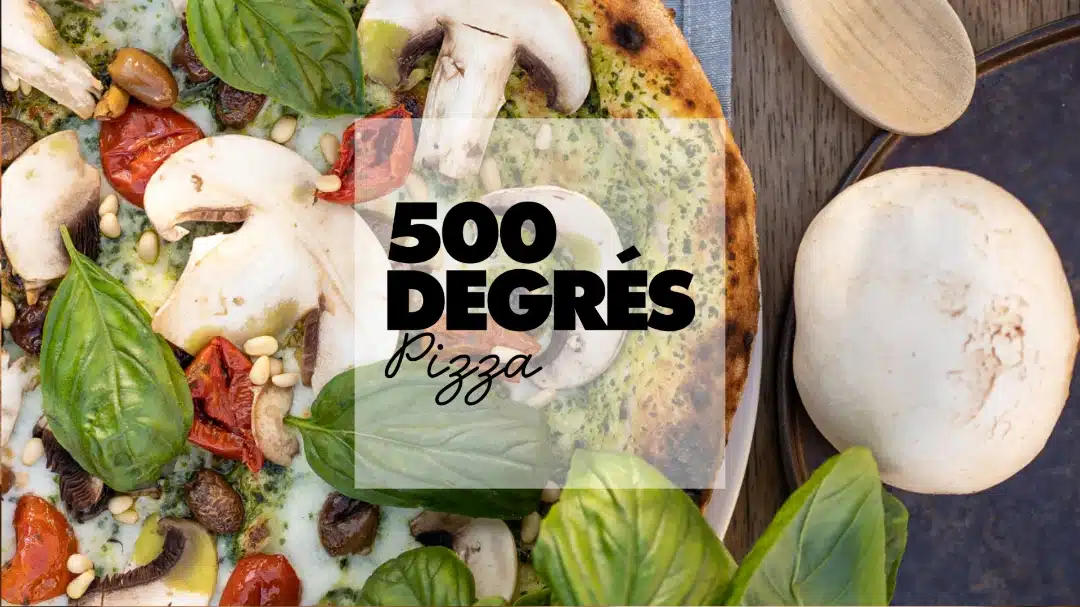 Gros plan d'une pizza garnie de champignons, tomates séchées et basilic avec le logo "500 Degrés Pizza" en surimpression.