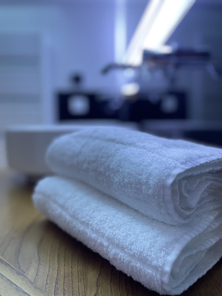 Serviettes blanches soigneusement pliées dans une ambiance relaxante, illustrant l’attention aux détails des Gîtes du Val d’Or.